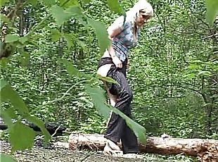 Cute blonde pissing on a long in the woods